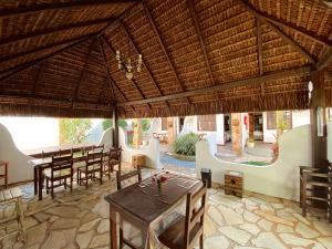 a restaurant with tables and chairs and a large roof at HOTELARE Hotel Brunello in Paraty