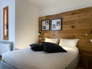 a bedroom with a large white bed with two pillows at Great Escapes in Ponte di Legno