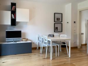 a dining room with a table and chairs and a tv at Great Escapes in Ponte di Legno