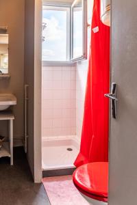 a bathroom with a shower and a red toilet at Le Debussy - studio - WIFI FIBRE- centre ville- parking in Tarbes