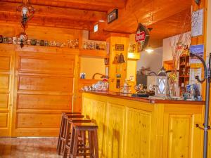 a kitchen with wooden cabinets and a bar with stools at Hostinec Hron - Beňuš in Beňuš
