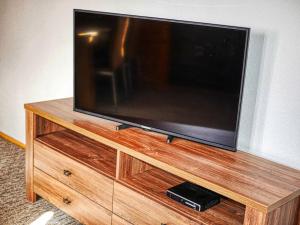 a flat screen tv sitting on top of a wooden entertainment center at Hostinec Hron - Beňuš in Beňuš