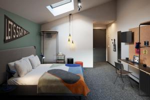 The Social Hub Madrid في مدريد: غرفة نوم مع سرير ومكتب مع تلفزيون