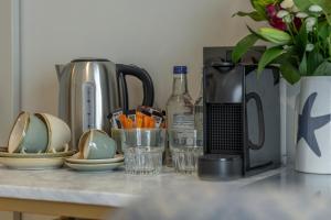 a counter top with a coffee maker and plates and cups at Oyster House in The Mumbles