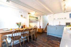 a kitchen and dining room with a wooden table and chairs at Artist Cottage in St Ives +12 photos
