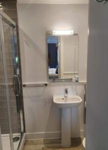 uma casa de banho com um lavatório e um chuveiro com um espelho. em The Plough Inn Ripple em Deal