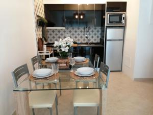 a dining room with a glass table and chairs at Apartamento de 2 Quartos no Centro de Monte Gordo in Monte Gordo