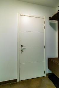 a white door with a metal handle on a wall at Laluna holiday apartment in Ostend