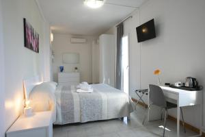a white bedroom with a bed and a desk at Hotel Mara in Rimini +79 photos