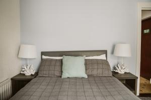 een slaapkamer met een bed met twee lampen op tafels bij 10 Bed Holiday Home in Portrush in Portrush