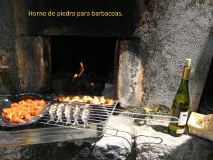 a grill with some food and a bottle of wine at CASA MARGARITAS in Ourense +12 photos