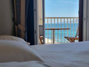 una camera con letto e vista sull'oceano di Hôtel U Paradisu a Porticcio