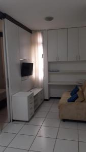 a white room with a tv and a bed in it at Park Studio in Brasilia