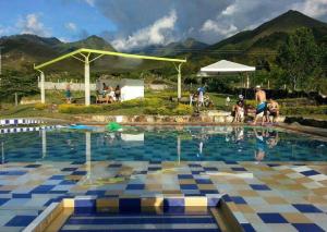 a large swimming pool with people standing around it at Finca Termópilas in Rivera
