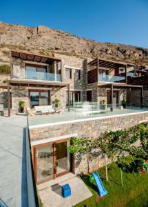 a stone house with a view of the backyard at Villa Dimitra by Elounda Island View Villas in Elounda