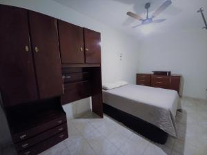 Apto 2 dormitórios no Boqueirão - Santos في سانتوس: غرفة نوم بسرير وخزانات خشبية