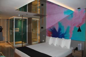 a bedroom with a bed with a colorful wall at Sky Motel Itaqua in Itaquaquecetuba