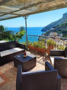 un patio con sillas y mesas de mimbre y el océano en Villa Marietta, en Minori