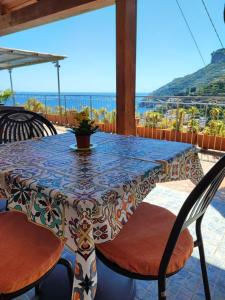una mesa y sillas en un patio con vistas al océano en Villa Marietta, en Minori