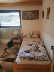 ein kleines Schlafzimmer mit einem Bett und einem Fenster in der Unterkunft Appartment in Heidenheim