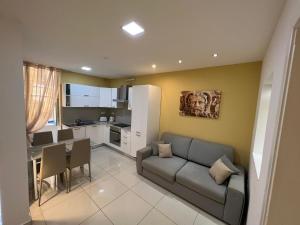 a living room with a couch and a table and a kitchen at St. Elmo Apartments in Valletta