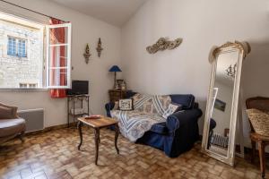 a living room with a blue chair and a mirror at Petit Paradis Nemausus in Nîmes