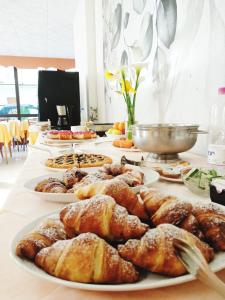 una mesa con varios platos de repostería. en Hotel Zenith en Rímini