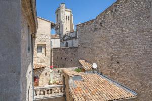 an alley in an old building with a tower at Petit Paradis Nemausus in Nîmes