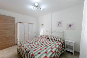 1 dormitorio con 1 cama con colcha roja y verde en Casetta Letizia - Goelba, en Portoferraio