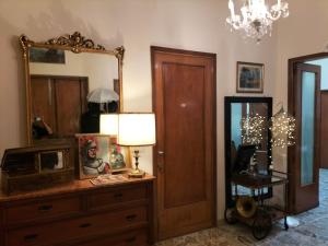 a room with a dresser with a mirror and a lamp at B&B Chapo in Catania