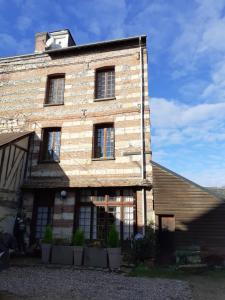 un vecchio edificio in mattoni con finestre laterali di Maison d'Hôtes Archangels Home a Saint-Saëns