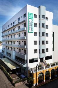 Un bâtiment blanc avec un panneau. dans l'établissement Gamma Villahermosa Centro, à Villahermosa