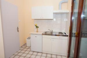 a small kitchen with white cabinets and a sink at Apartmani Centar Makarska in Makarska +33 photos