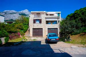 un coche aparcado frente a una casa en Apartmani Centar Makarska en Makarska