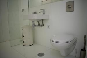 a white bathroom with a toilet and a sink at Nova Casa com Piscina no Convento das Bernardas in Tavira +18 photos