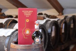 a bottle of wine sitting on top of a barrel at Real BB Balsamico in Bastiglia