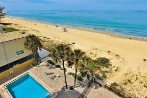 - une vue sur la plage avec piscine et palmiers dans l'établissement Shore House 502, à Clearwater Beach