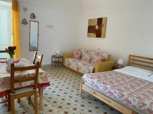 ein Schlafzimmer mit einem Bett, einem Stuhl und einem Sofa in der Unterkunft Ponzamania Casa Silvana Ponza in Ponza