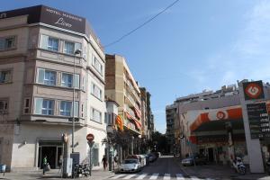 a street in a city with buildings and cars at Hotel Madanis Liceo in Hospitalet de Llobregat