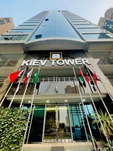 a new towers building with flags in front of it at Kiev Tower Hotel Apartments in Manama