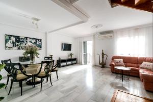 una sala de estar con un sofá y una mesa en BeHouse Mairena, en Mairena del Aljarafe