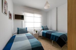 Un dormitorio con dos camas y una ventana en BeHouse Mairena, en Mairena del Aljarafe 29 fotos más
