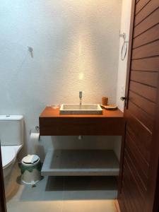 een badkamer met wastafel en toilet bij Vila Gameleira Garça in Maceió