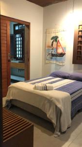 een slaapkamer met een bed met een schilderij aan de muur bij Vila Gameleira Garça in Maceió