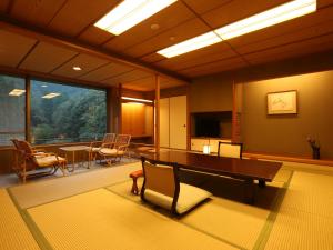 una sala con tavolo e sedie e una sala da pranzo di Kinosaki Onsen Nishimuraya Hotel Shogetsutei a Toyooka