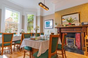 uma sala de jantar com uma mesa e cadeiras e uma lareira em Egans House em Dublin