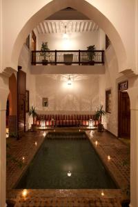 una piscina cubierta en un edificio con un arco en Riad Les Bougainvilliers, en Marrakech