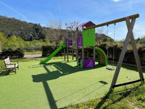 un parc avec une aire de jeux avec un toboggan dans l'établissement Safaritent Glamping de L'Olivigne, à Bize-Minervois