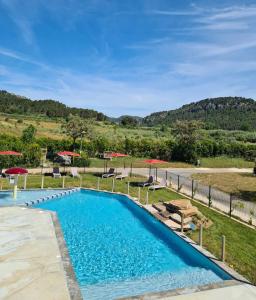une piscine avec chaises et parasols dans un complexe hôtelier dans l'établissement Safaritent Glamping de L'Olivigne, à Bize-Minervois 9 autres photos