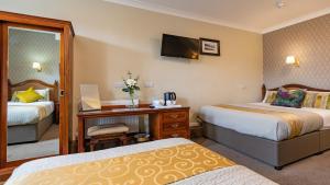 um quarto de hotel com duas camas e uma secretária em Egans House em Dublin